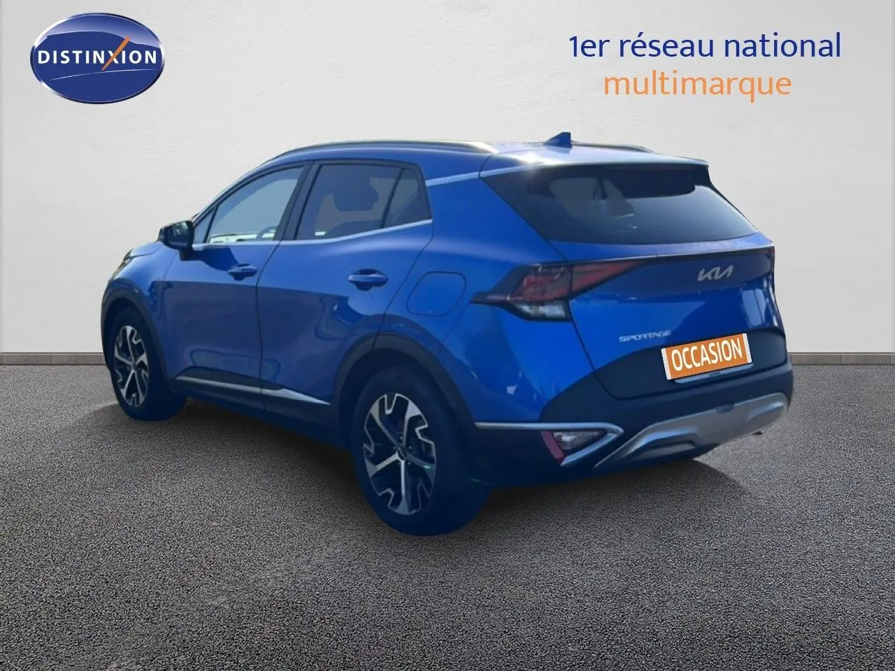 Vue 3/4 arrière droite d'un Kia Sportage bleu fusion métal avec jantes alliage et feux arrière LED.