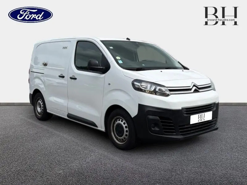 Vue 3/4 avant droit d'un utilitaire Citroën Jumpy blanc Banquise avec pare-chocs noirs et jantes acier.