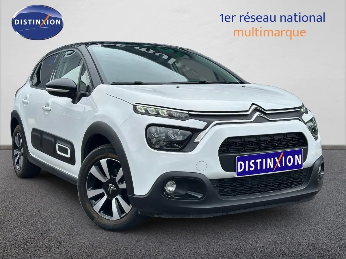 Citroën C3 blanc Banquise vue 3/4 avant droit avec protections latérales noires et jantes alu bicolores.
