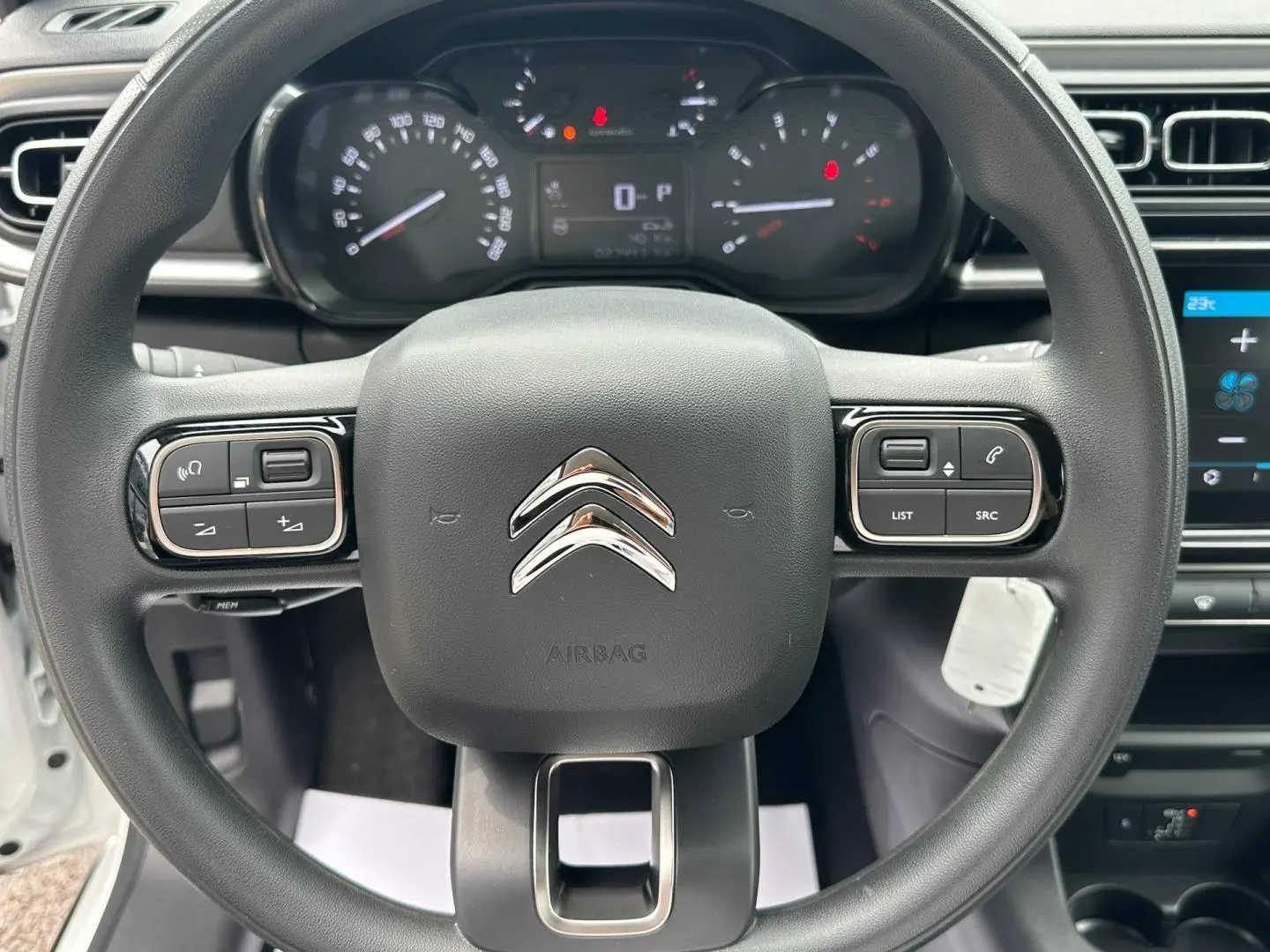 Vue rapprochée du volant noir de la Citroën C3 2023, avec tableau de bord et commandes intégrées visibles.