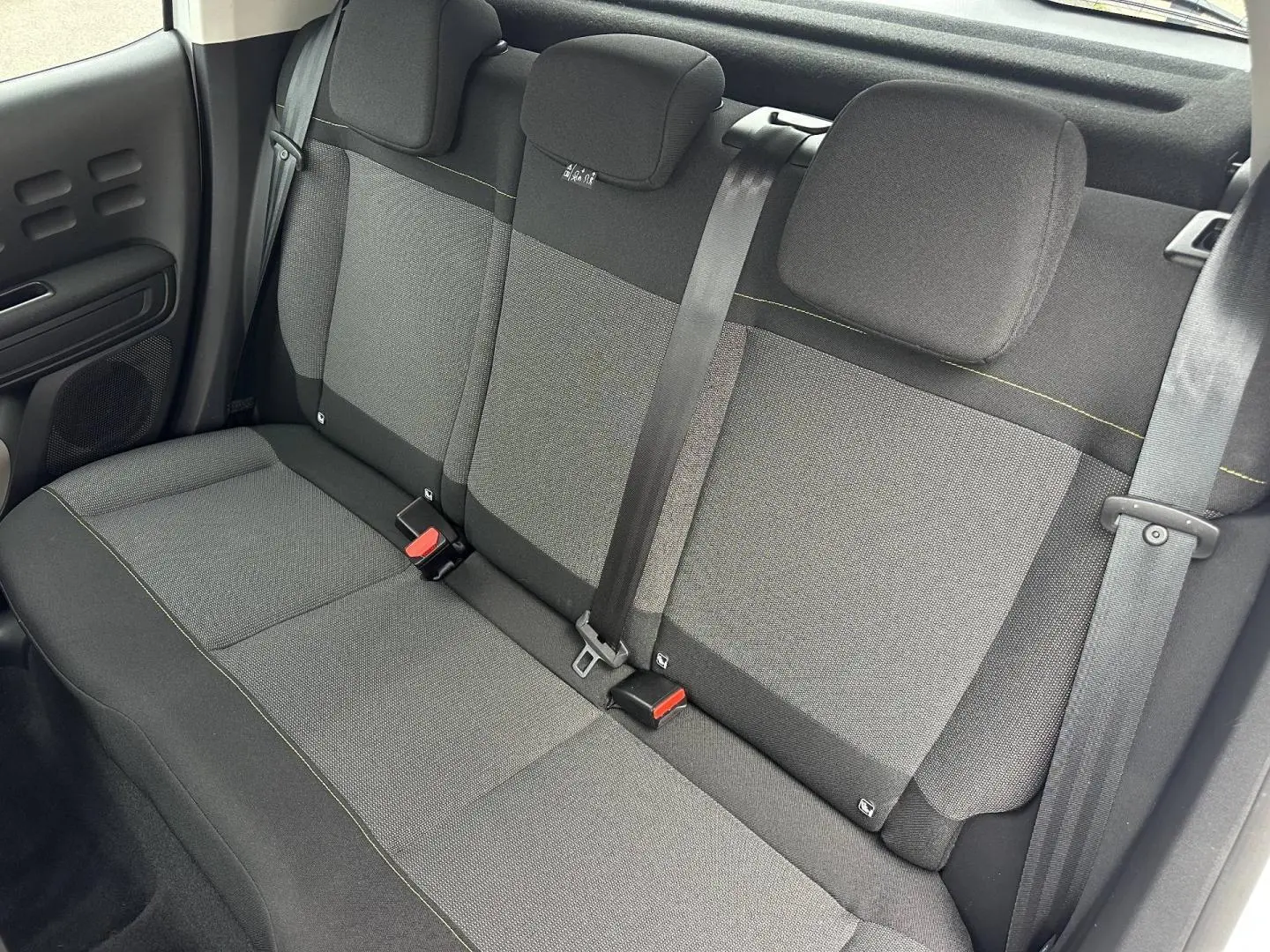 Vue intérieure de la banquette arrière en tissu gris avec ceintures de sécurité de la Citroën C3 Blanc Banquise 2023.