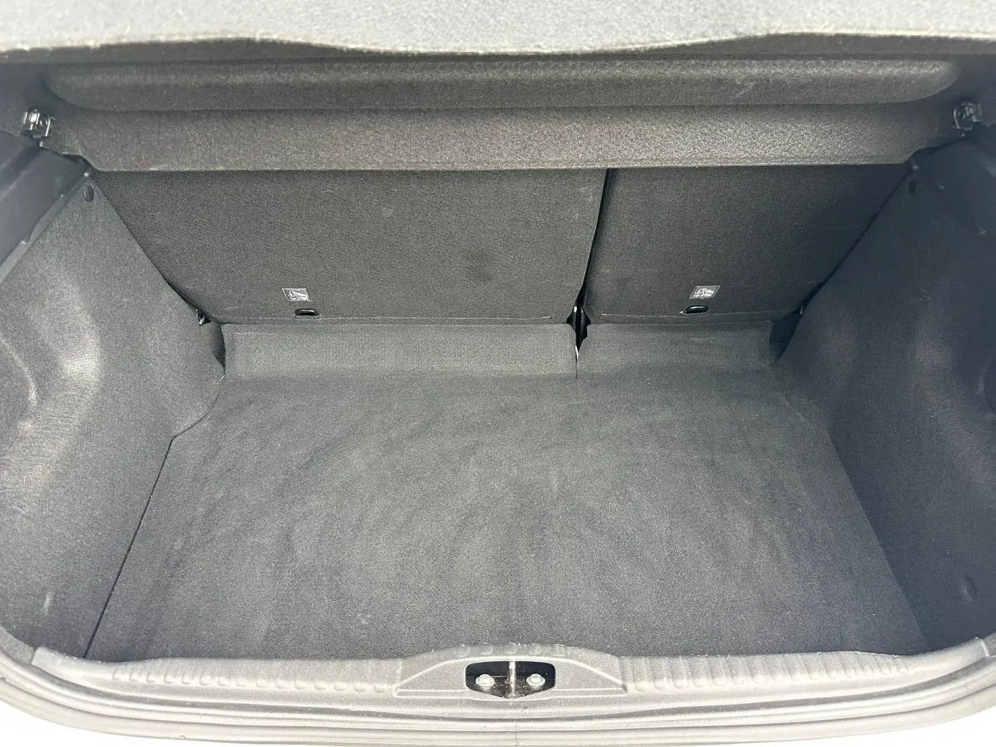 Coffre vide de Citroën C3 blanc Banquise, vue intérieure arrière avec banquette rabattable en tissu gris.