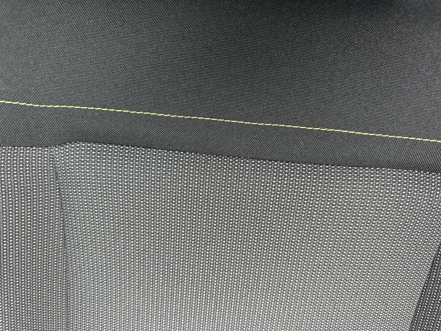 Gros plan sur le tissu Mica Grey avec surpiqûres jaunes du siège avant d’une Citroën C3 blanche Banquise 2023.