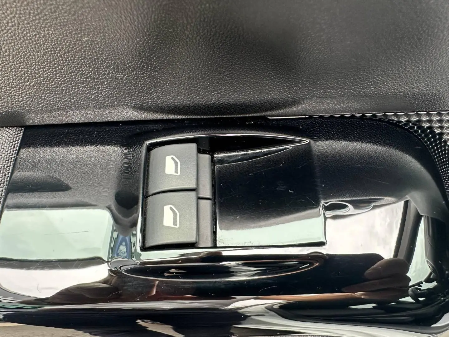 Gros plan sur les commandes de lève-vitres électriques côté conducteur de la Citroën C3 blanche Banquise.