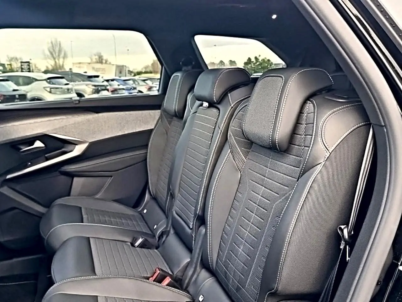 Vue intérieure côté droit sur les sièges arrière noirs en tissu et cuir du Peugeot 5008 Hybrid 145 GT e-dcs6 2026.