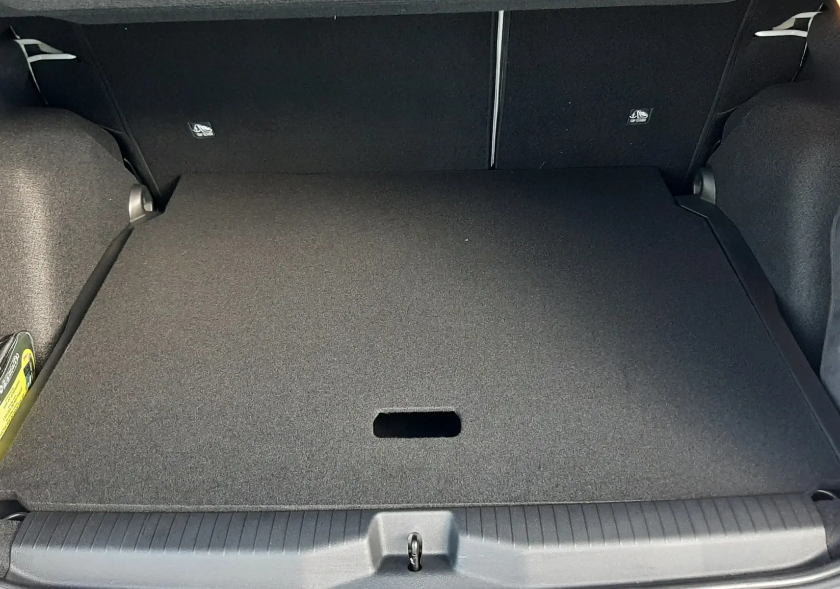 Coffre ouvert vu de l'arrière d'une Citroën C3 Aircross 1.2 Hybrid 145ch blanc avec toit noir, intérieur de coffre noir.