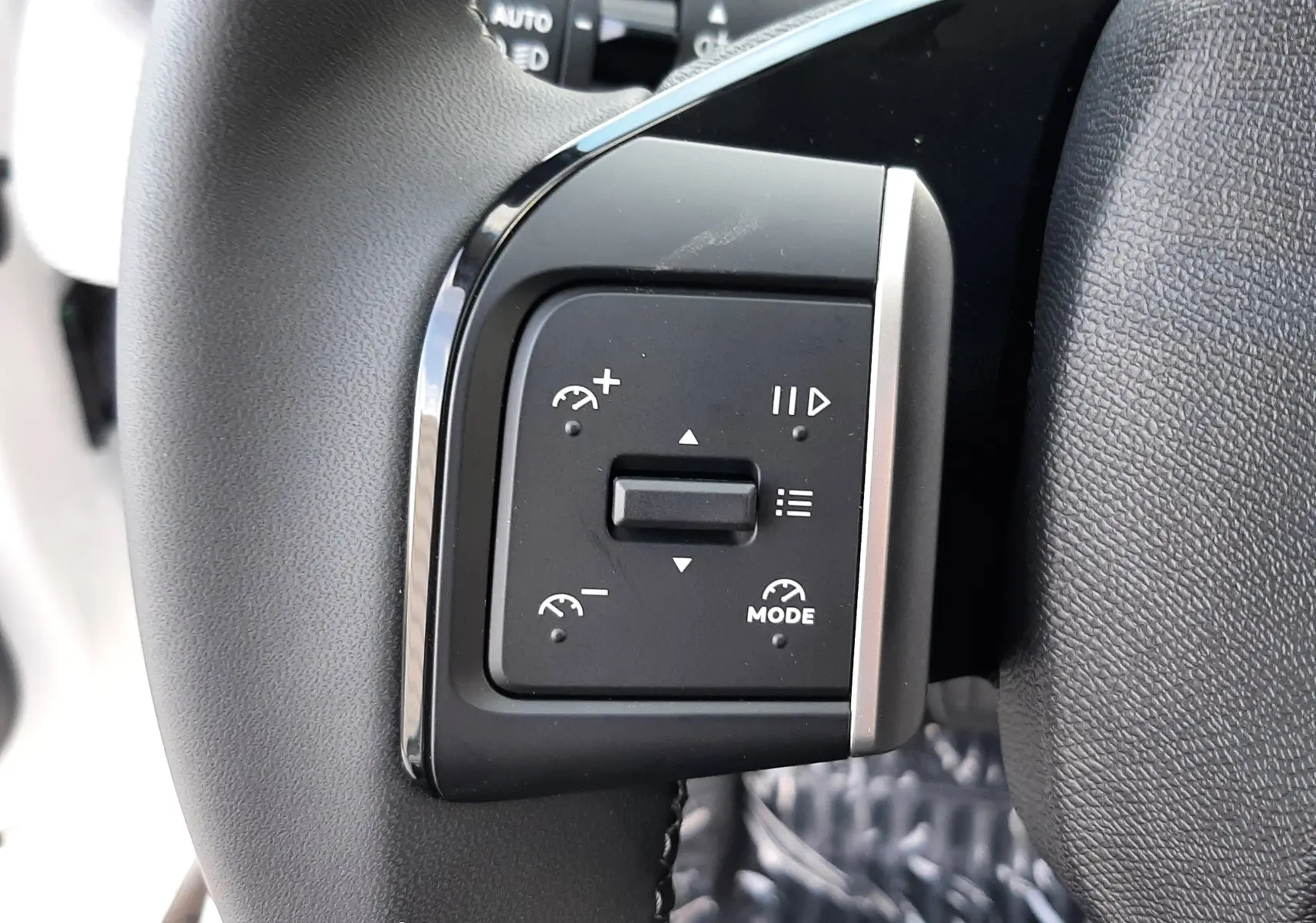 Gros plan sur les commandes de régulateur de vitesse au volant noir du Citroën C3 Aircross hybride 2026.