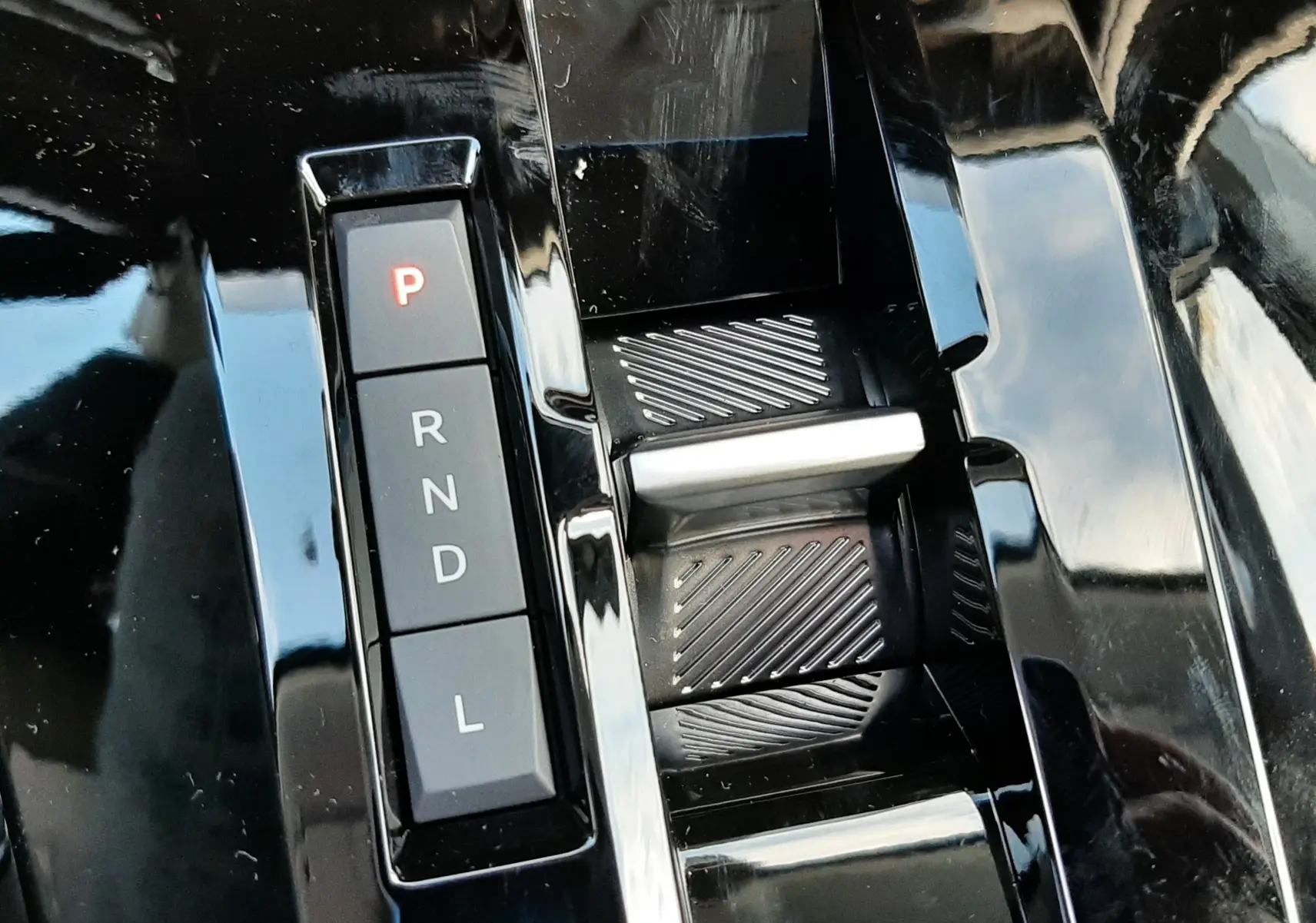 Gros plan sur la commande de boîte automatique noire du Citroën C3 Aircross 1.2 Hybrid 145ch, avec bouton "P" éclairé en rouge.