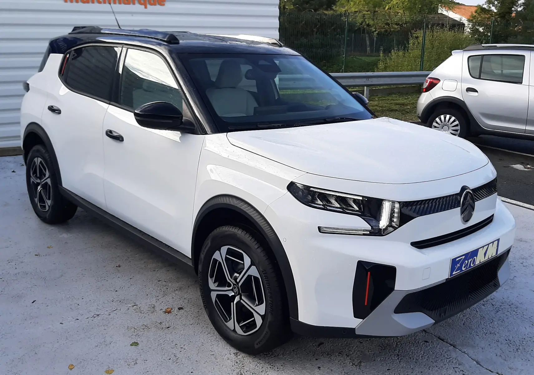 Vue 3/4 avant droit du Citroën C3 Aircross blanc avec toit noir, roues alliage et calandre moderne.