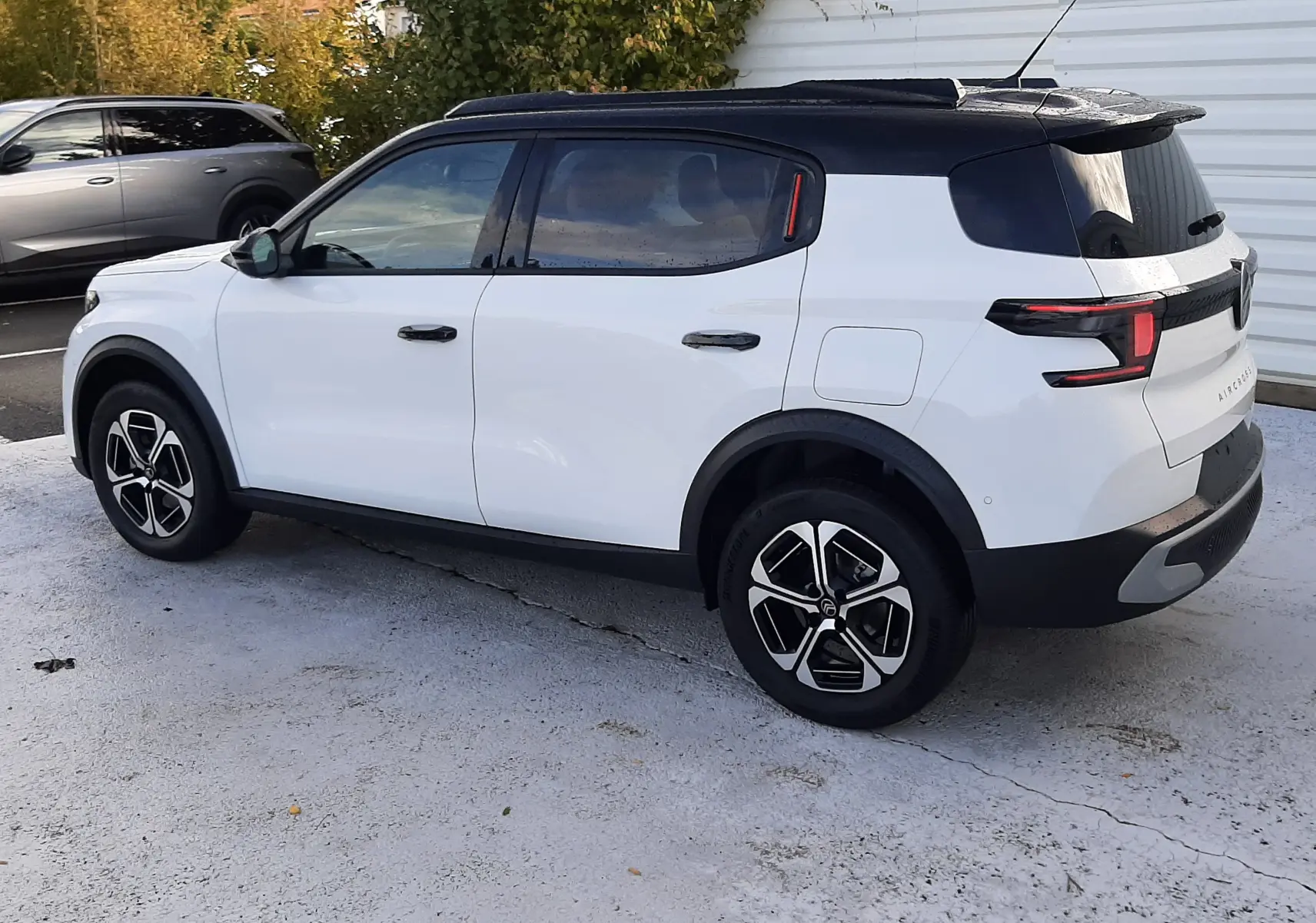 Citroën C3 Aircross blanc toit noir, vue 3/4 arrière côté gauche, jantes noires et design moderne des feux arrière LED.