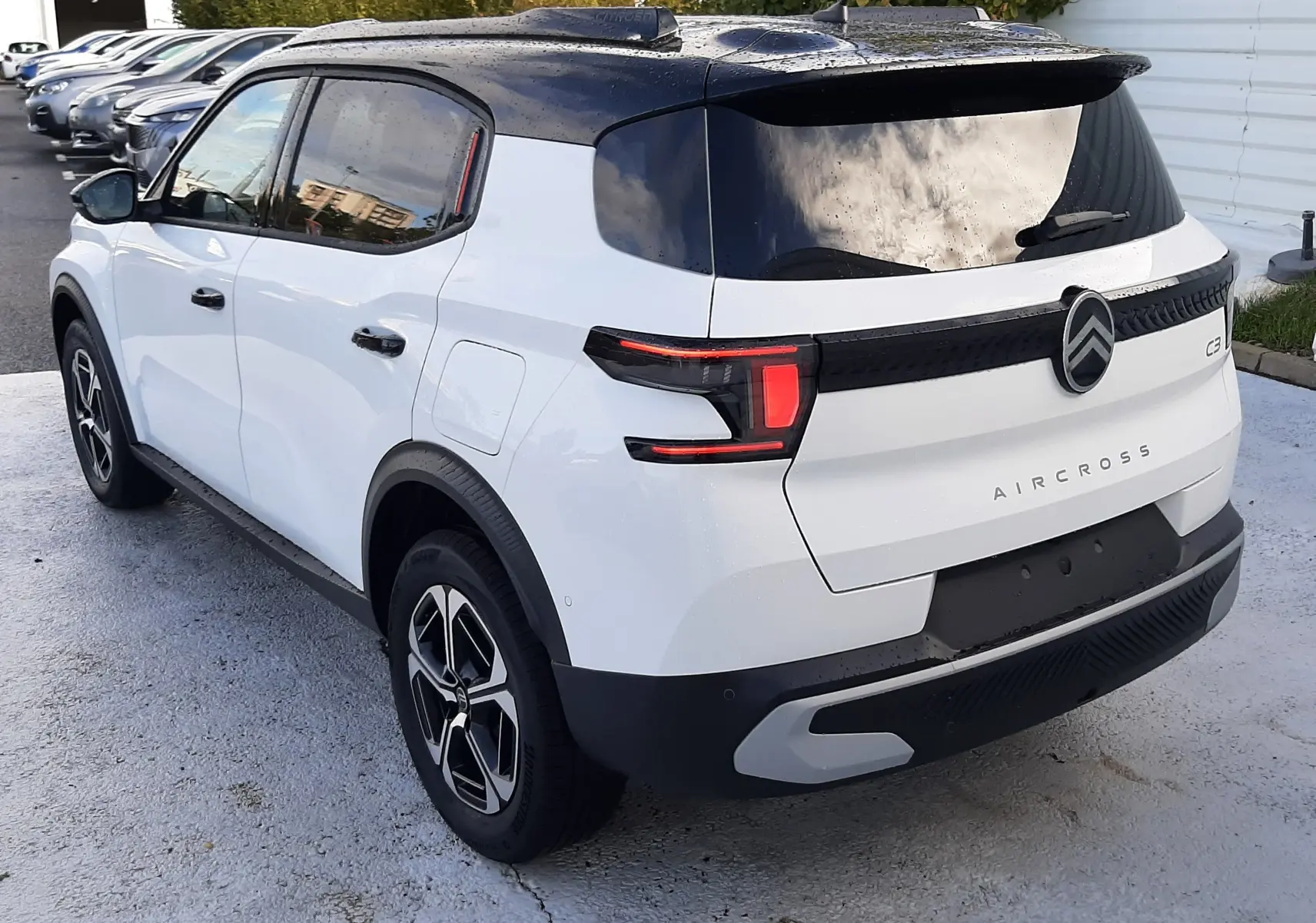 Vue 3/4 arrière droite du Citroën C3 Aircross blanc avec toit noir, feux arrière LED et jantes alliage.