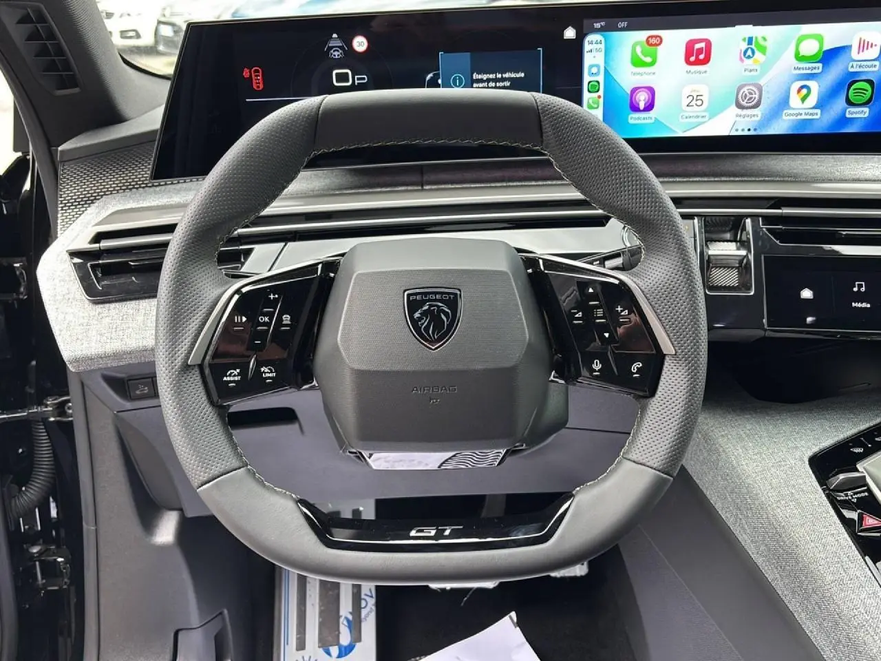 Vue rapprochée du volant cuir perforé gris du Peugeot 3008 GT 2026 avec tableau de bord numérique panoramique et écran tactile.
