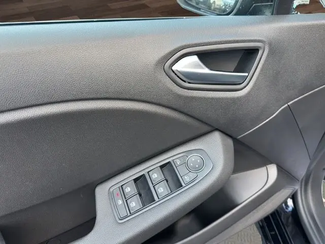 Détail de la porte côté conducteur noire d'une Renault Clio V 2025, avec commandes électriques des vitres et poignée argentée.