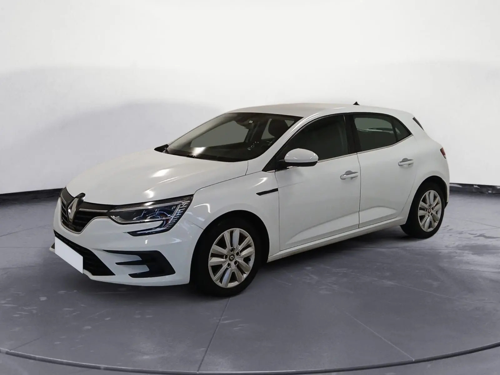 Renault Mégane IV blanche vue en 3/4 avant droit, avec phares LED et jantes alliage, sur fond neutre intérieur.