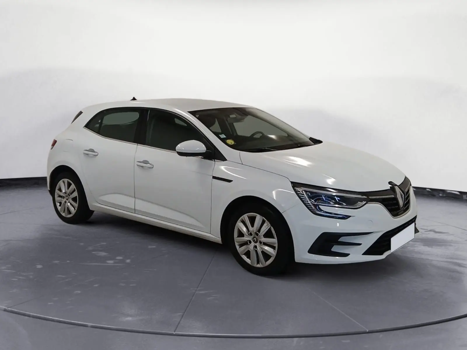 Renault Mégane IV blanche vue en 3/4 avant droit, avec phares LED et calandre noire distinctive.