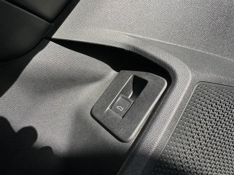 Détail du bouton d'ouverture du coffre dans l'habitacle noir du CUPRA Formentor 1.5 eTSI Hybrid 2025.