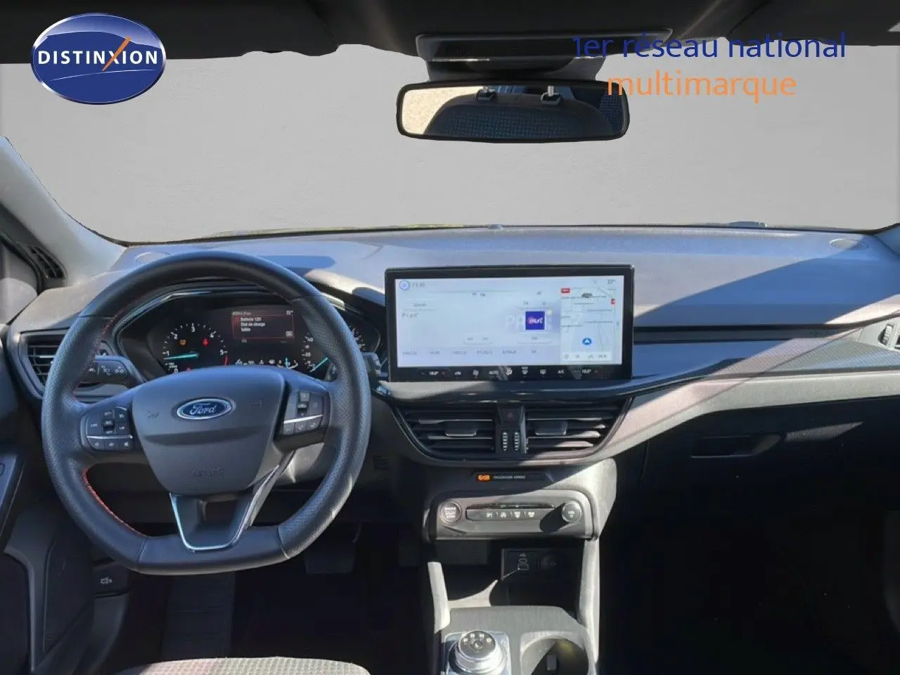 Vue frontale de l’habitacle de la Ford Focus SW noire, avec tableau de bord numérique et grand écran tactile central.