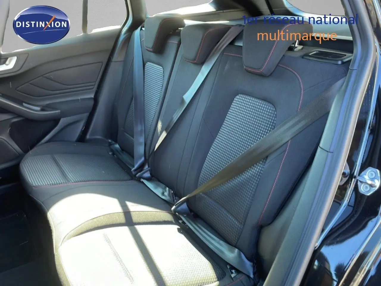 Vue intérieure côté arrière droit de la banquette tissu noir avec surpiqûres rouges de la Ford Focus SW 2024 noir Agate Metal.