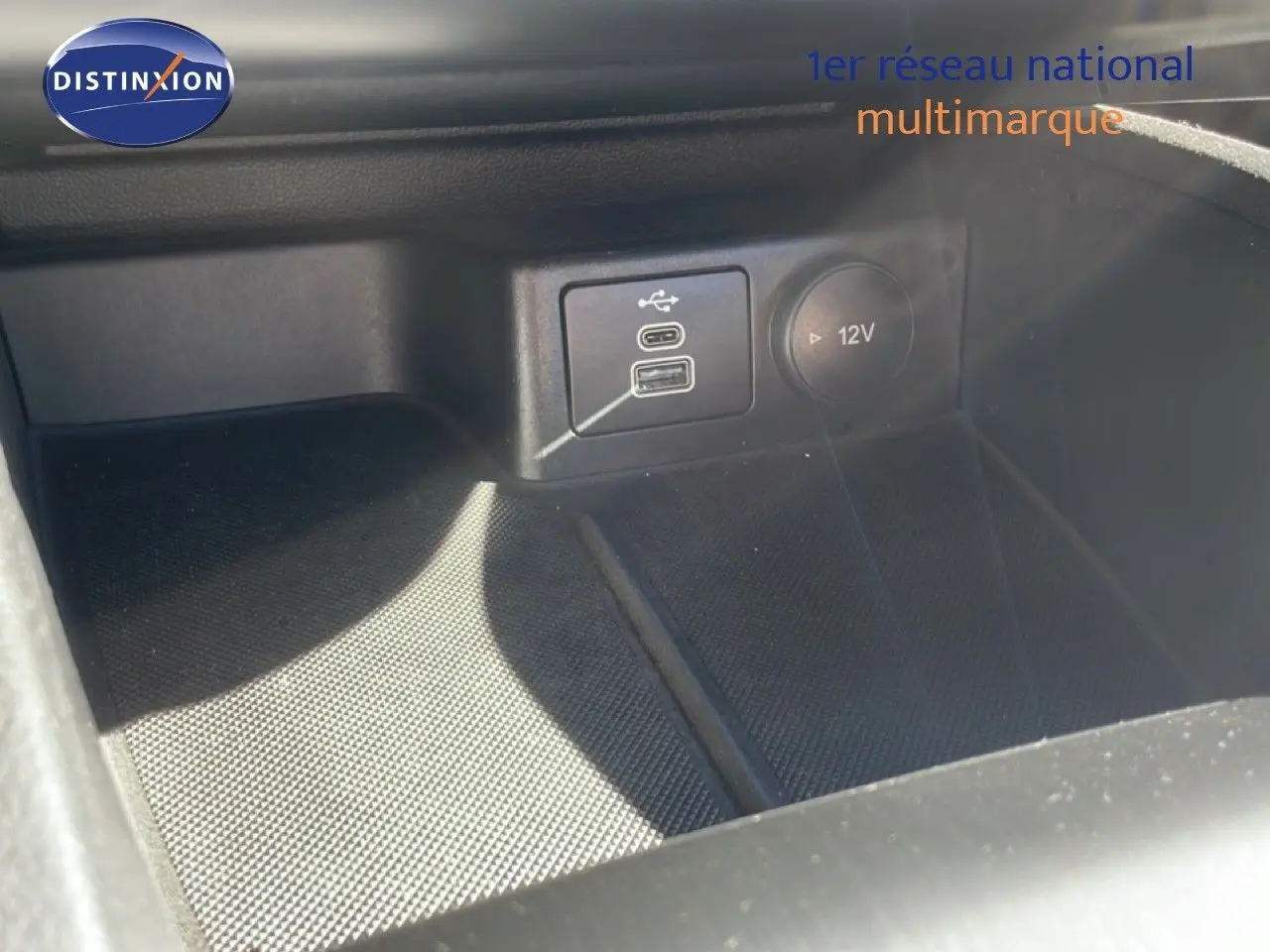 Prise USB et prise 12V en gros plan dans l’habitacle noir de la Ford Focus SW 1.5 EcoBlue 2024.
