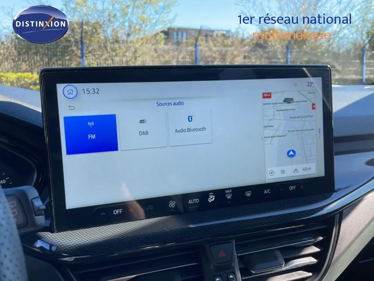 Vue intérieure du tableau de bord de la Ford Focus SW 2024 noir agate, avec écran tactile central affichant les sources audio et la navigation.