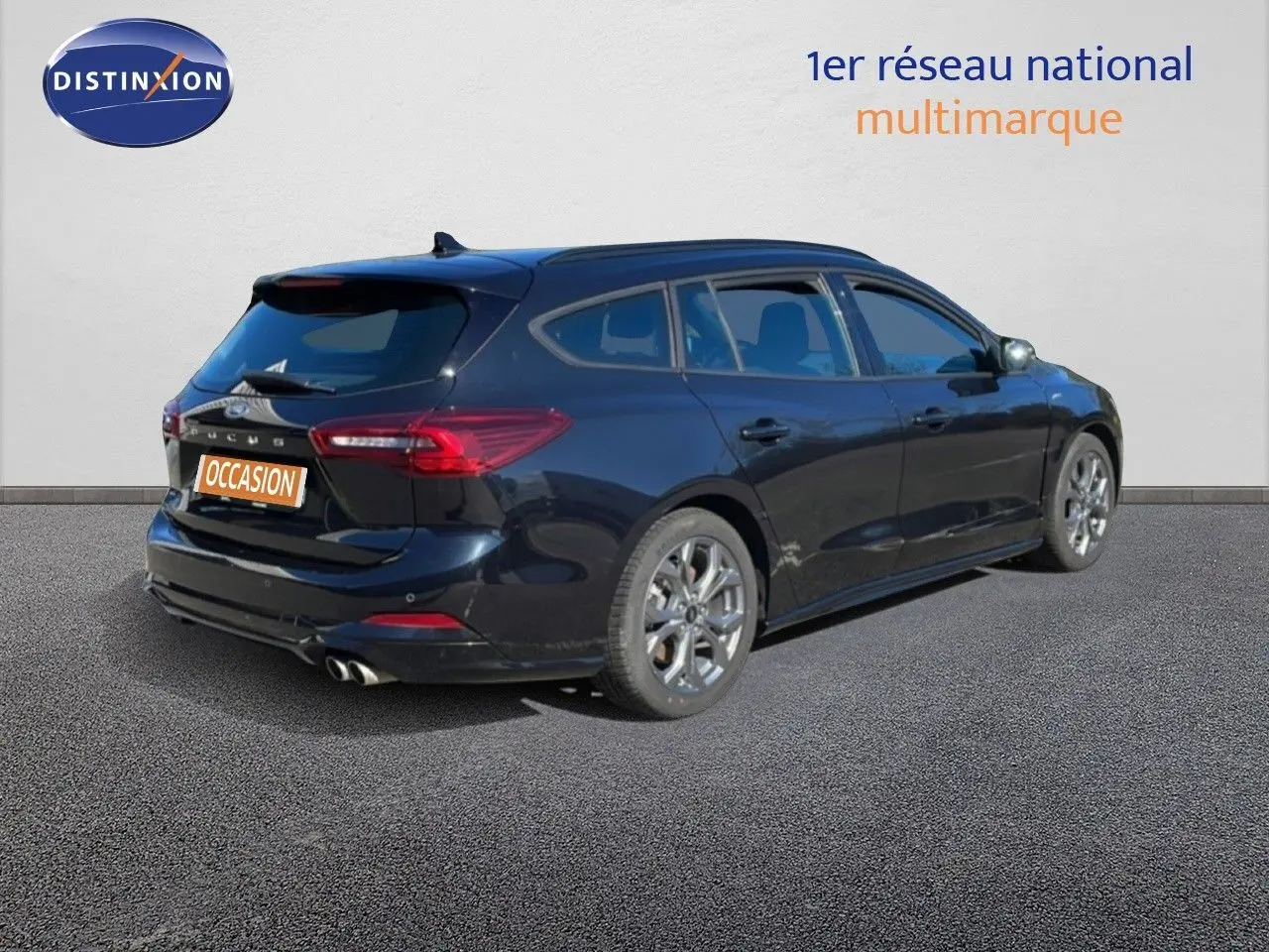 Vue 3/4 arrière droite d’une Ford Focus SW noire Agate Metal, avec jantes alliage et double sortie d’échappement.