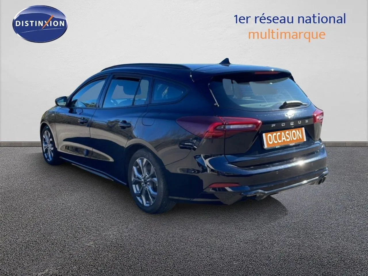 Ford Focus SW noir agate métal vue 3/4 arrière droit, break diesel 2024 avec jantes alliage et feux LED.