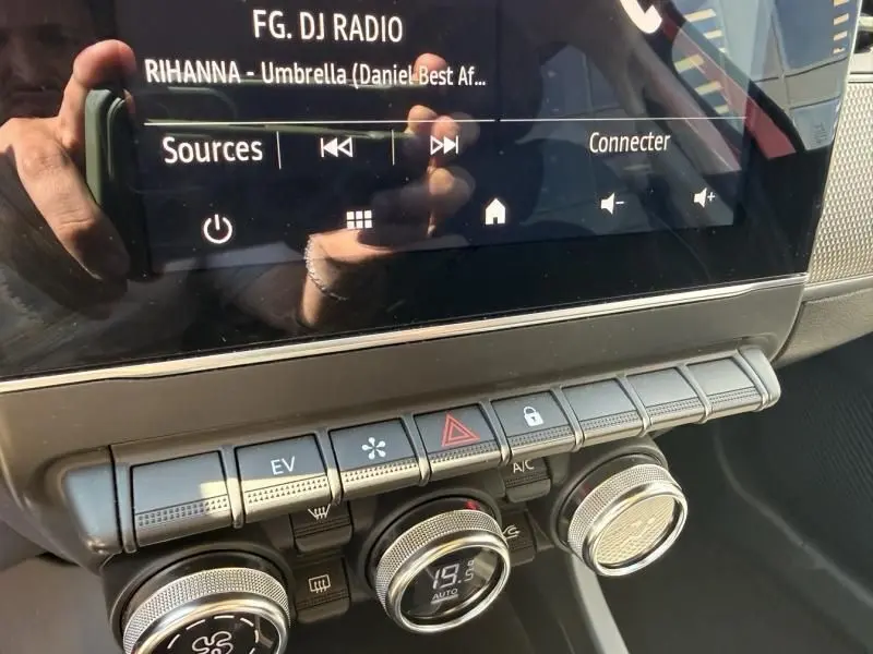 Détail de la console centrale du Renault Arkana rouge flamme 2022, montrant les commandes climatisation et écran tactile.