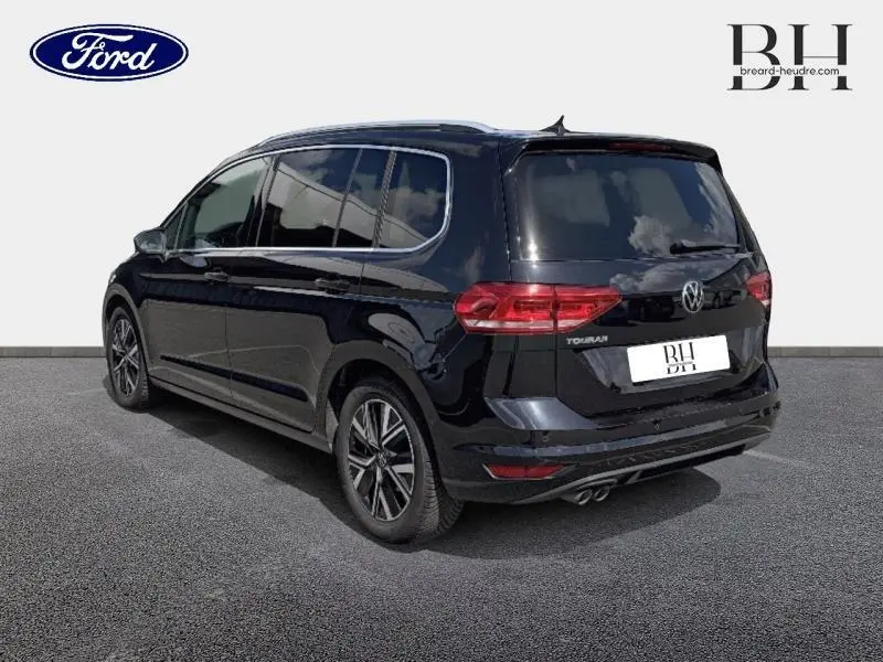 Volkswagen Touran noir intense nacré vu en 3/4 arrière droit, avec vitres teintées et jantes alliage.