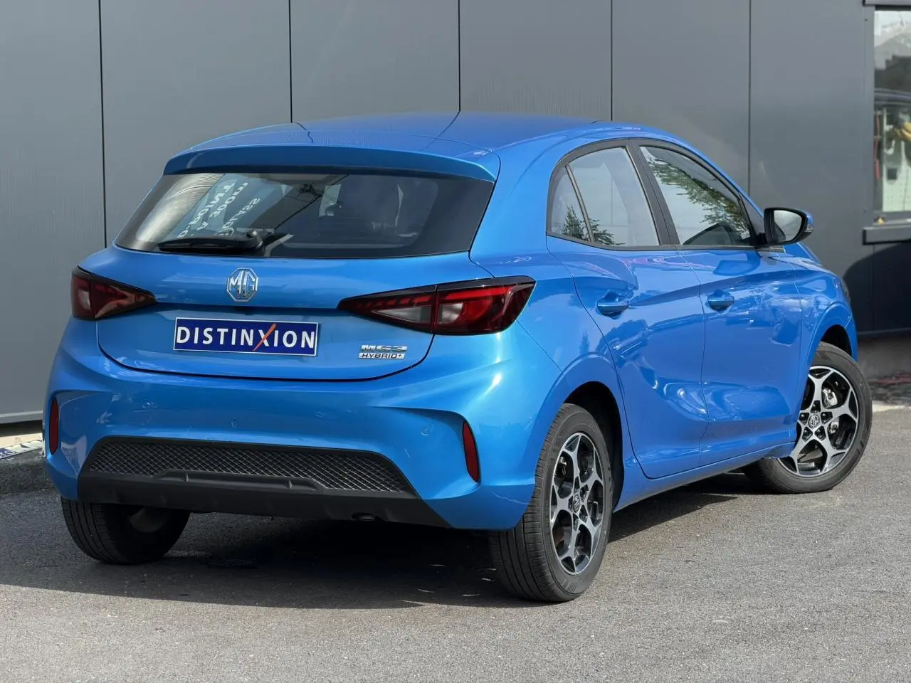 Vue 3/4 arrière droite d'une MG3 hybride bleu Como avec jantes alliage et feux arrière LED distinctifs.