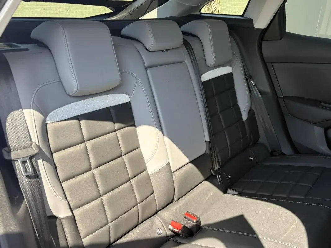 Vue intérieure des sièges arrière en cuir bi-ton gris et noir de la Citroën C4 Hybrid 2025.