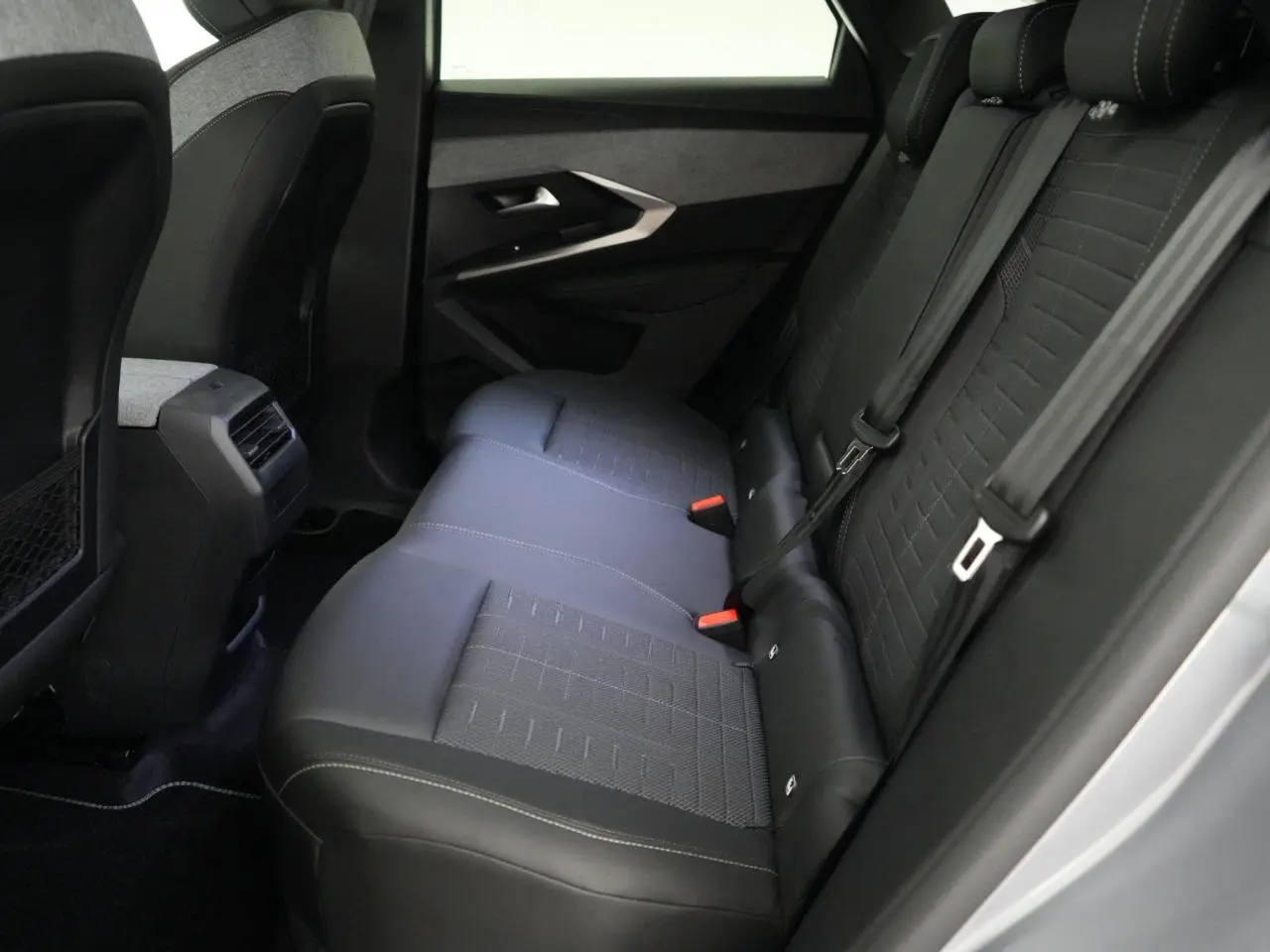 Vue intérieure côté droit des sièges arrière noirs avec surpiqûres blanches du Peugeot 3008 gris Artense 2026.