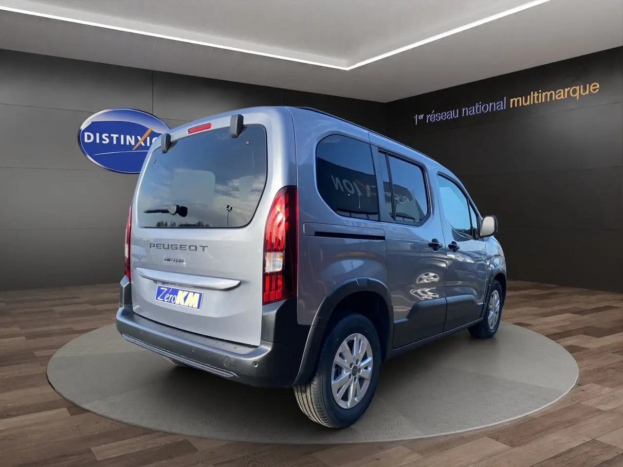 Peugeot Rifter gris acier vue 3/4 arrière droit, vitres surteintées et hayon avec lunette ouvrable.