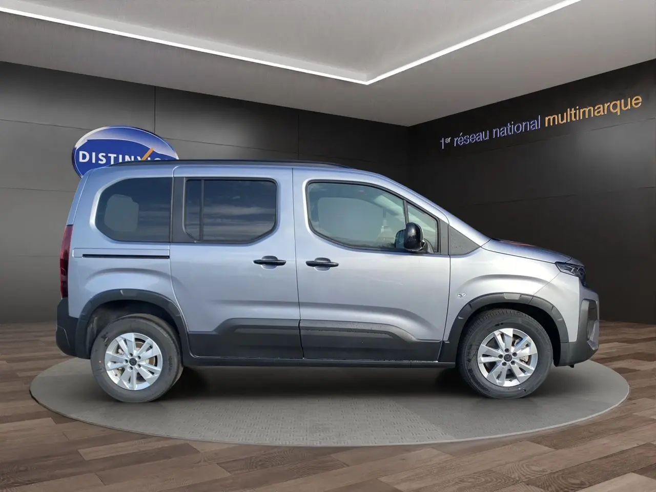 Peugeot Rifter gris acier vu de profil côté gauche, avec jantes alliage 16'' et portes coulissantes.