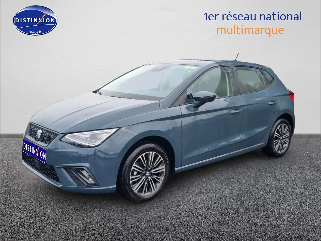 Vue 3/4 avant d'une SEAT Ibiza 1.0 TSI 95 Copa bleu gris avec jantes alliage et phares LED triangulaires.