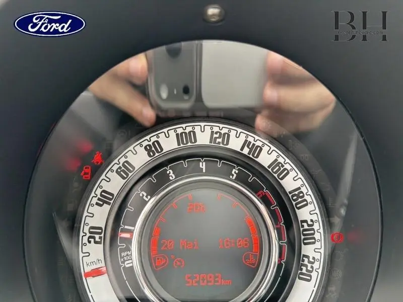 Vue rapprochée du compteur de vitesse circulaire de la FIAT 500 blanche, affichant 52093 km et informations numériques rouges.