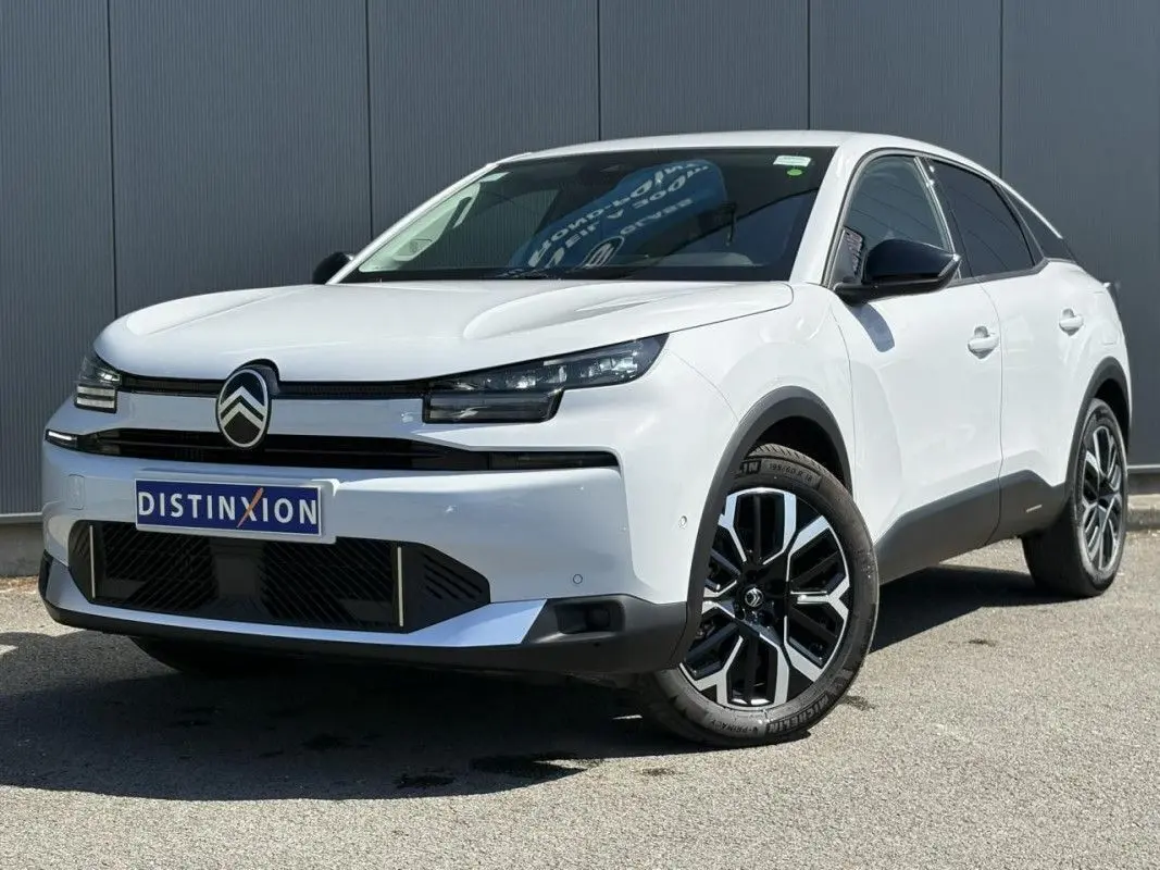 Vue 3/4 arrière droite d'une Citroën C4 Hybrid blanche Okenite avec toit noir brillant et feux arrière LED distinctifs.