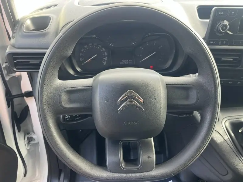 Vue frontale du volant noir du Citroën Berlingo Fourgon blanc, avec tableau de bord et commandes visibles.