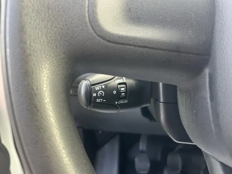 Gros plan sur la commande de régulateur de vitesse sous le volant du Citroën Berlingo Fourgon blanc Banquise 2021.