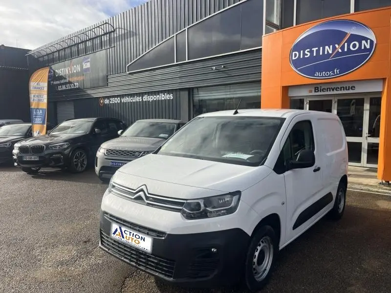 Citroën Berlingo Fourgon blanc Banquise en 3/4 avant droit devant un garage Distinxion.