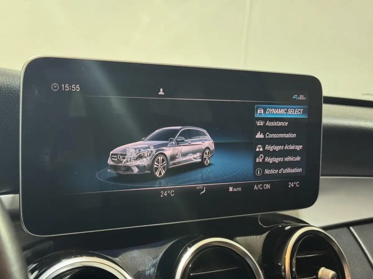 Écran central intérieur montrant une Mercedes Classe C Break noire en vue 3/4 avec menu Dynamic Select.