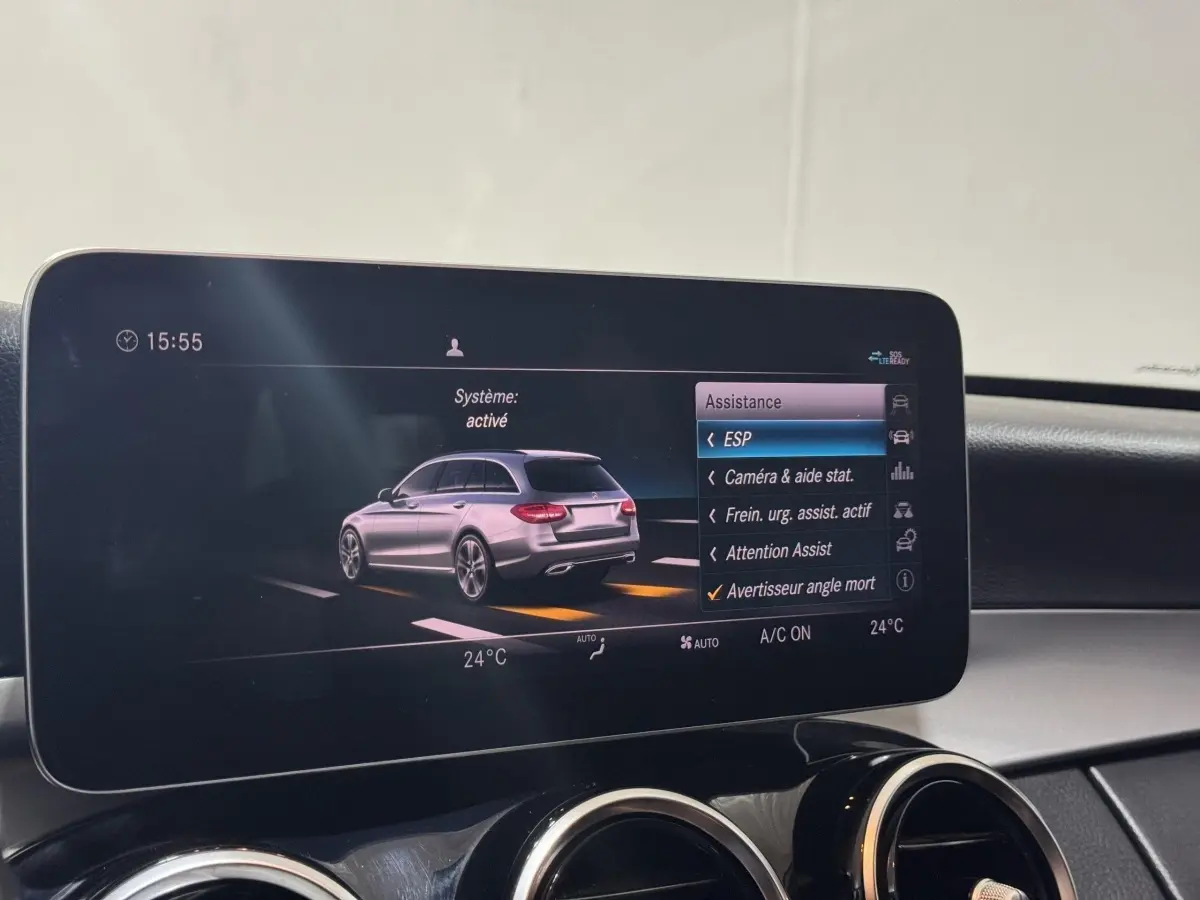 Écran central affichant l'aide à la conduite avec vue 3/4 arrière d'une Mercedes Classe C Break noire.