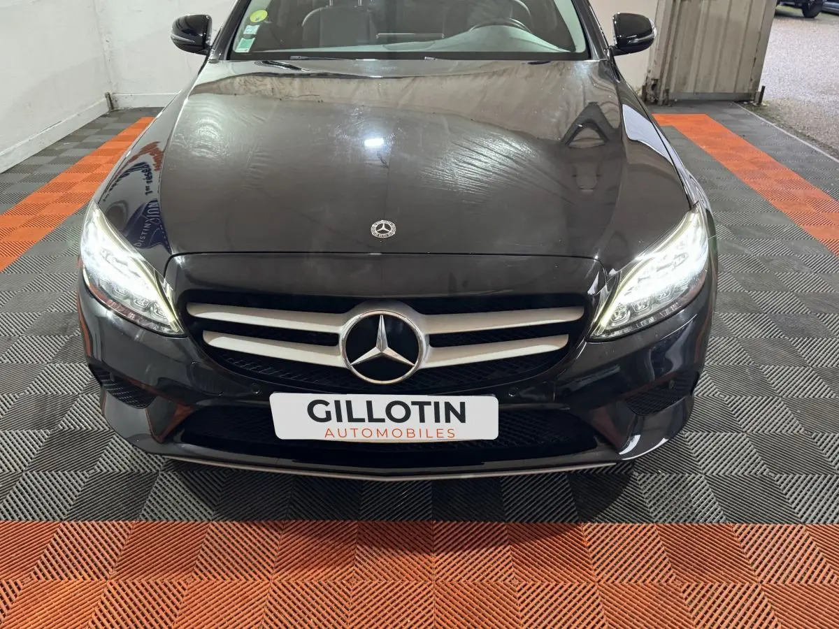 Vue frontale rapprochée d'une Mercedes Classe C Break C 200 d Business Line noire avec phares LED allumés.