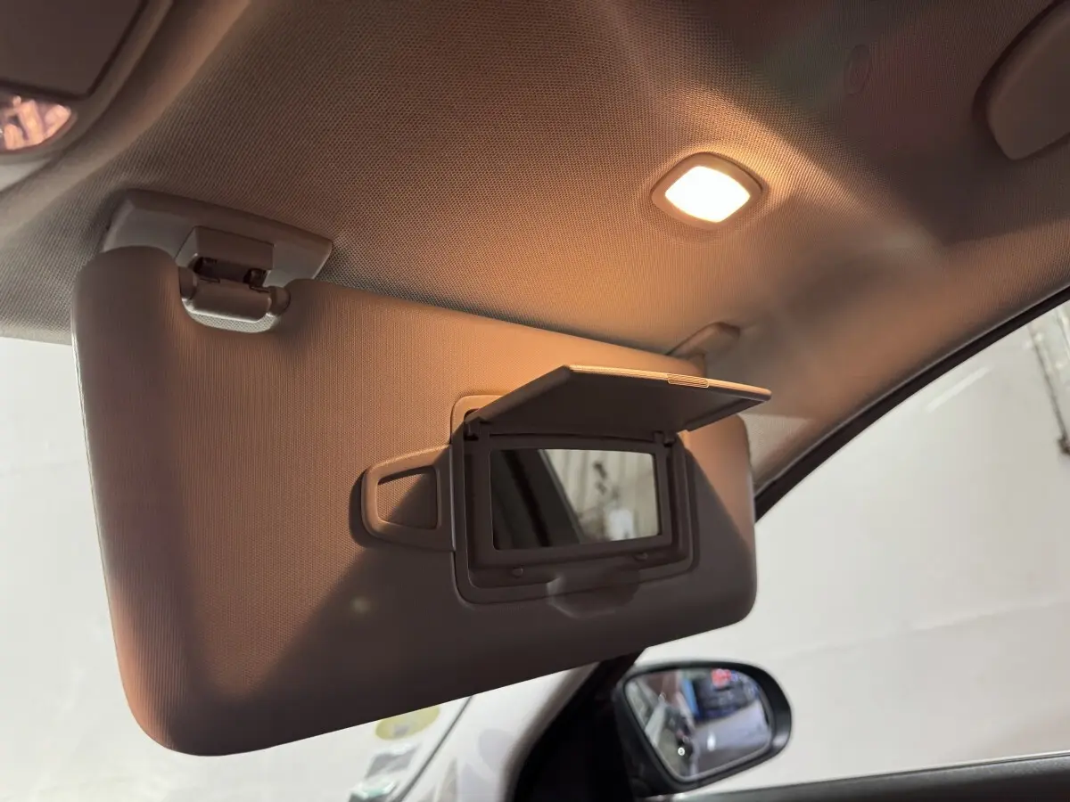 Miroir de courtoisie ouvert sur pare-soleil côté conducteur dans l'habitacle d'une Mercedes Classe C Break noire.