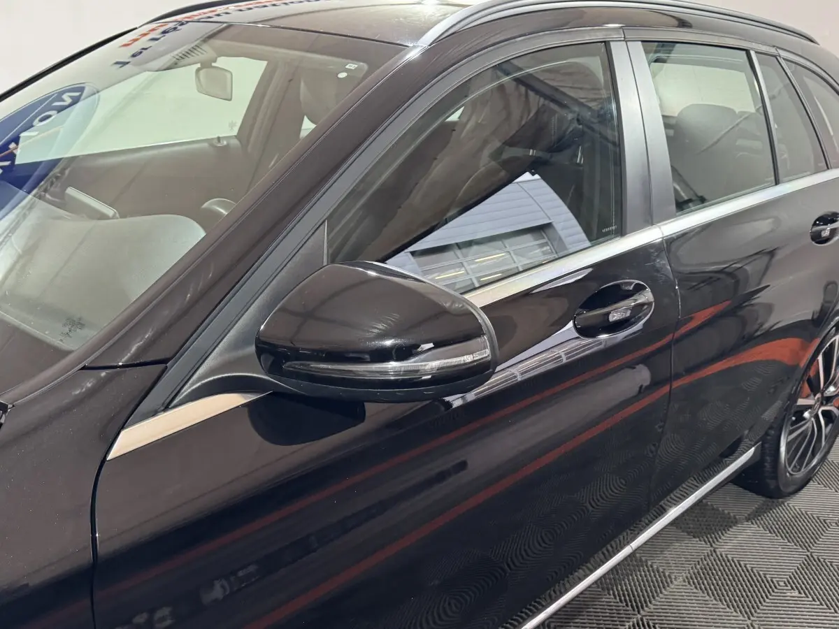 Vue rapprochée du côté gauche d'une Mercedes Classe C Break C 200 d Business Line noire, mettant en valeur la portière et le rétroviseur.