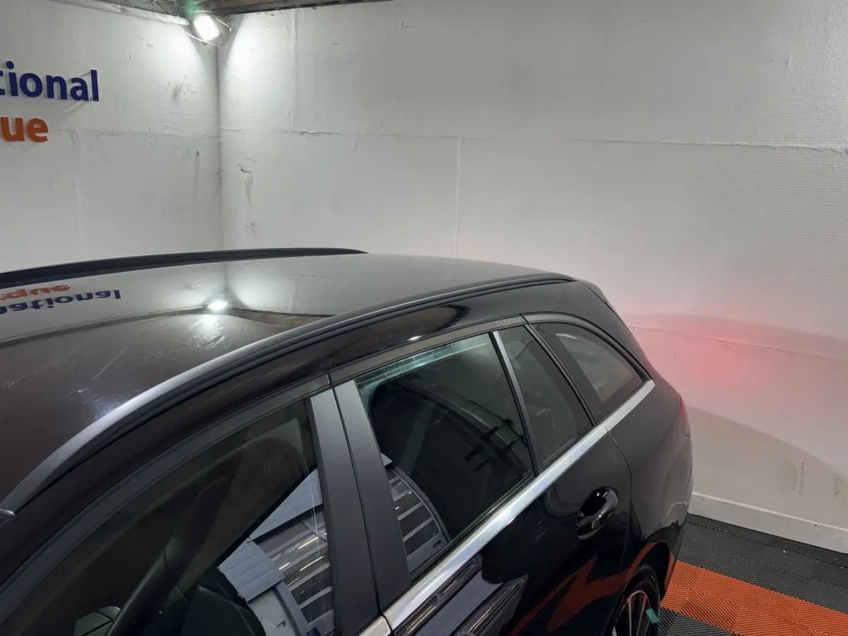 Vue 3/4 arrière côté droit d'un Mercedes Classe C Break C 200 d Business Line noir stationné en intérieur.