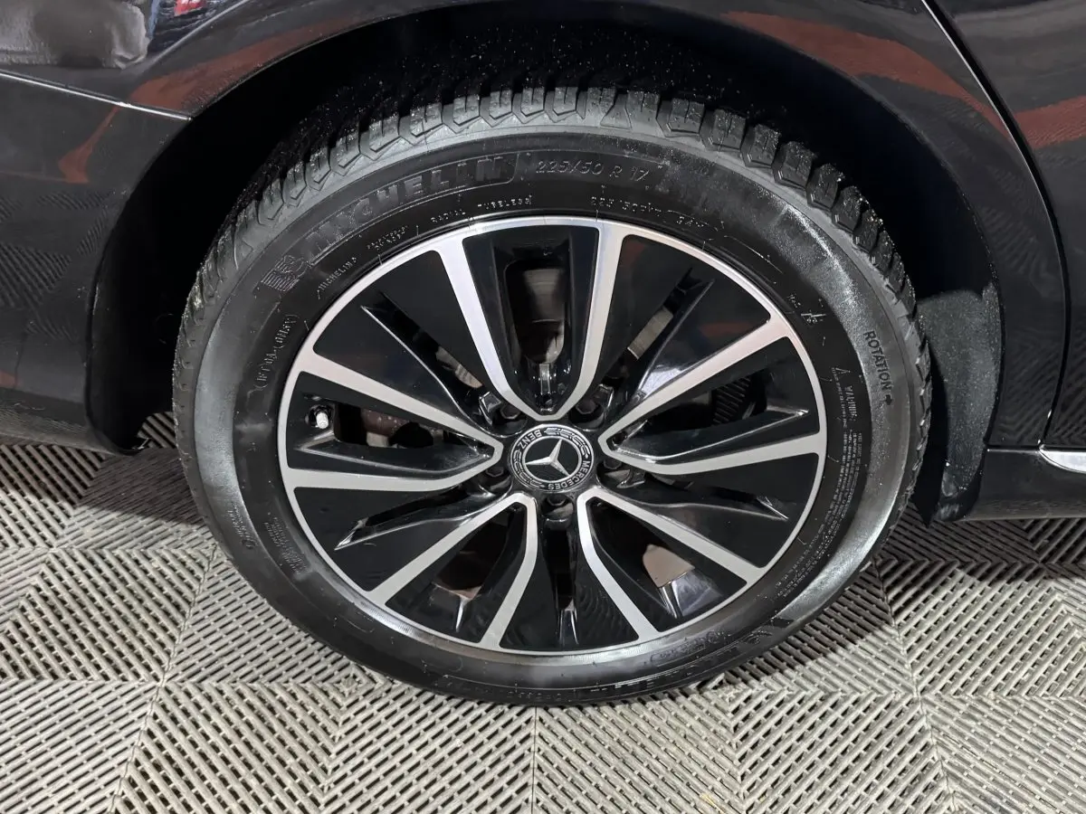 Gros plan sur la roue avant gauche noire d’un Mercedes Classe C Break C 200 d Business Line avec jante alliage bicolore.