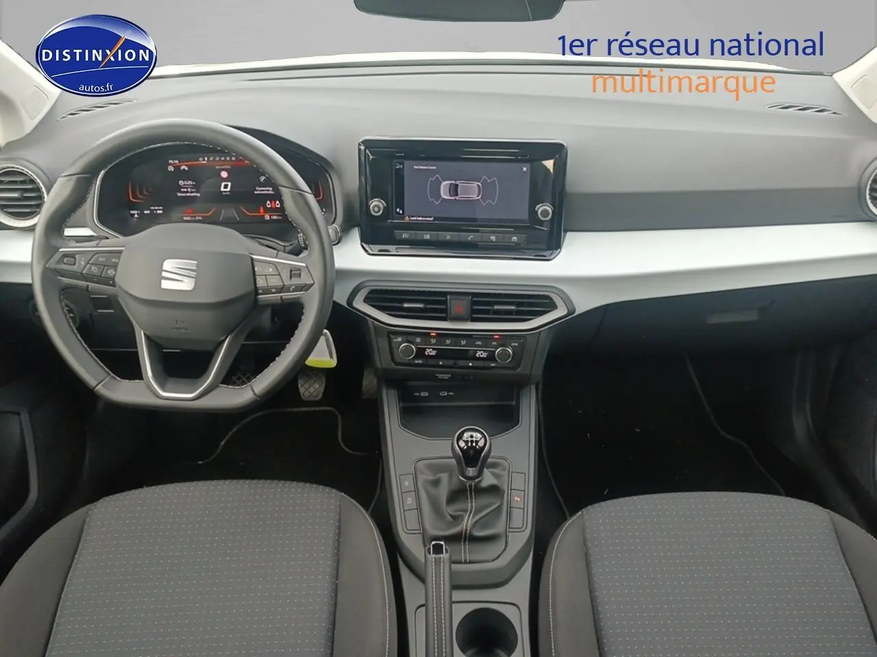 Vue intérieure frontale du poste de conduite de la SEAT Ibiza 2025 avec volant cuir, tableau de bord digital et levier de vitesse manuel.
