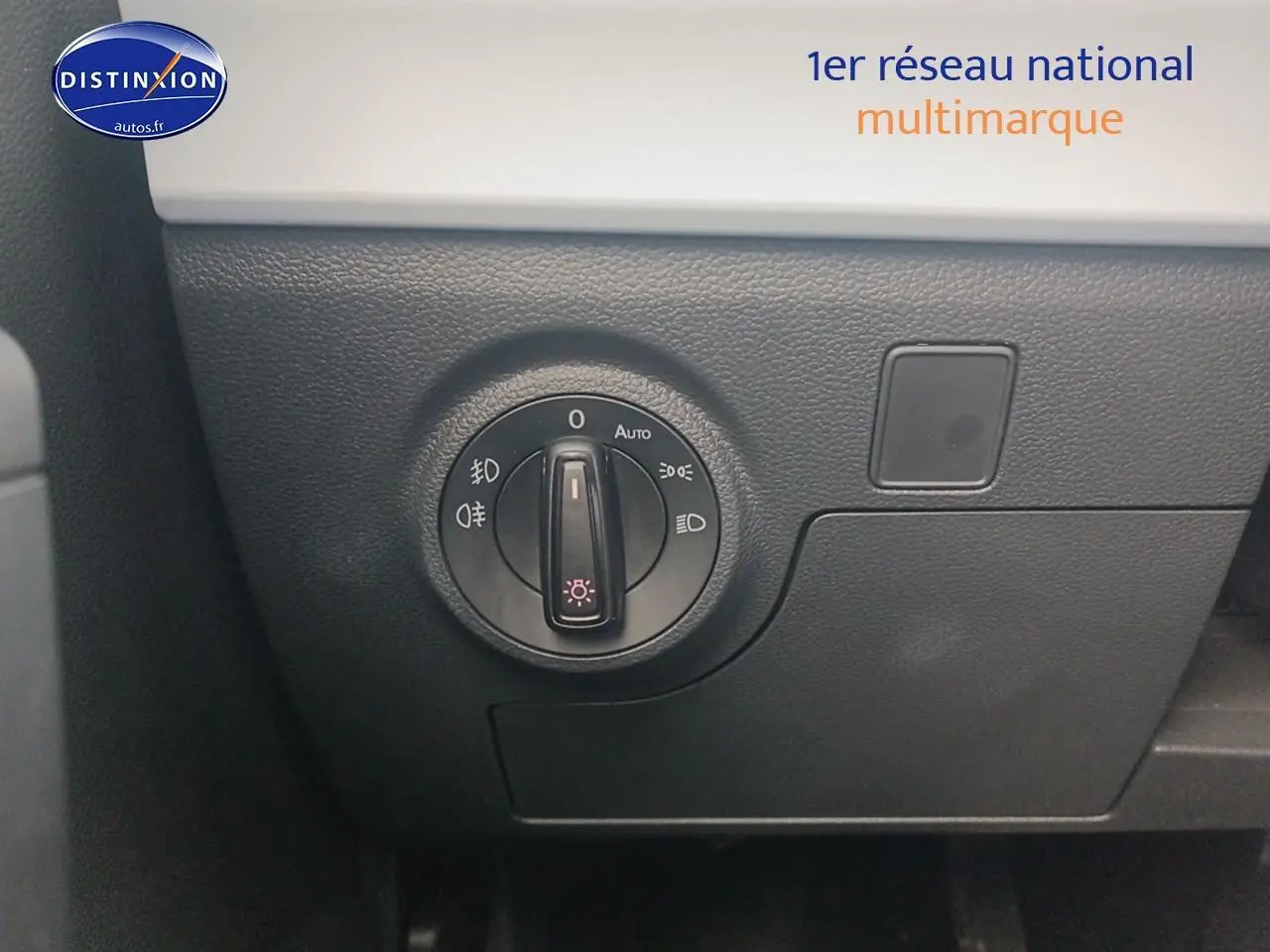 Gros plan sur le bouton de commande des phares dans l'habitacle de la SEAT Ibiza blanc Nevada 2025.