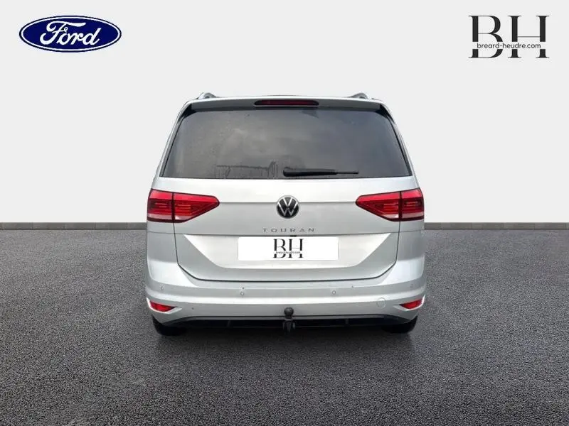 Vue arrière d'un Volkswagen Touran 2021 gris argent métallisé avec attelage et vitres arrière surteintées.