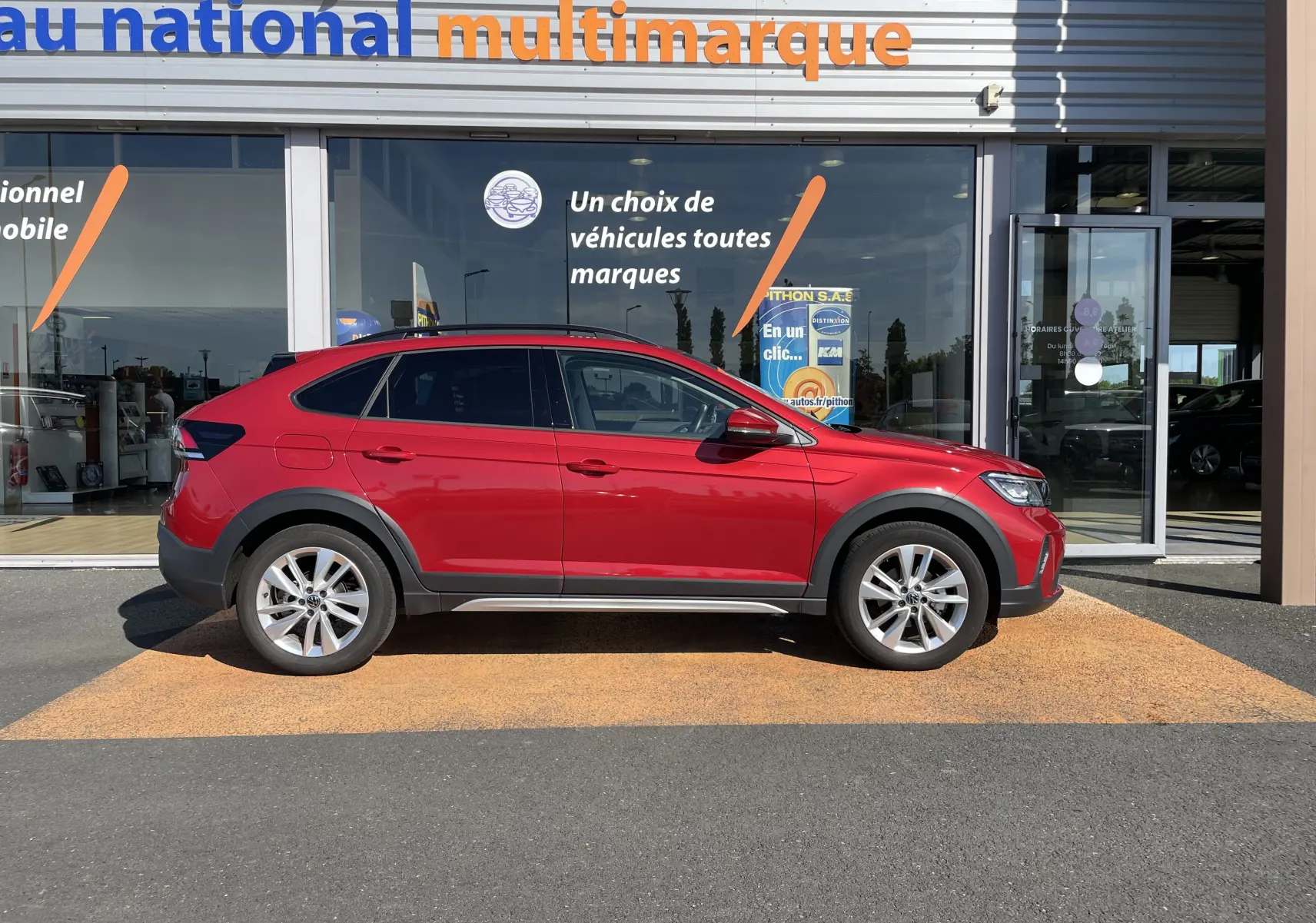 Volkswagen Taigo rouge roi vue de profil côté gauche, SUV compact avec jantes alliage et protections noires.